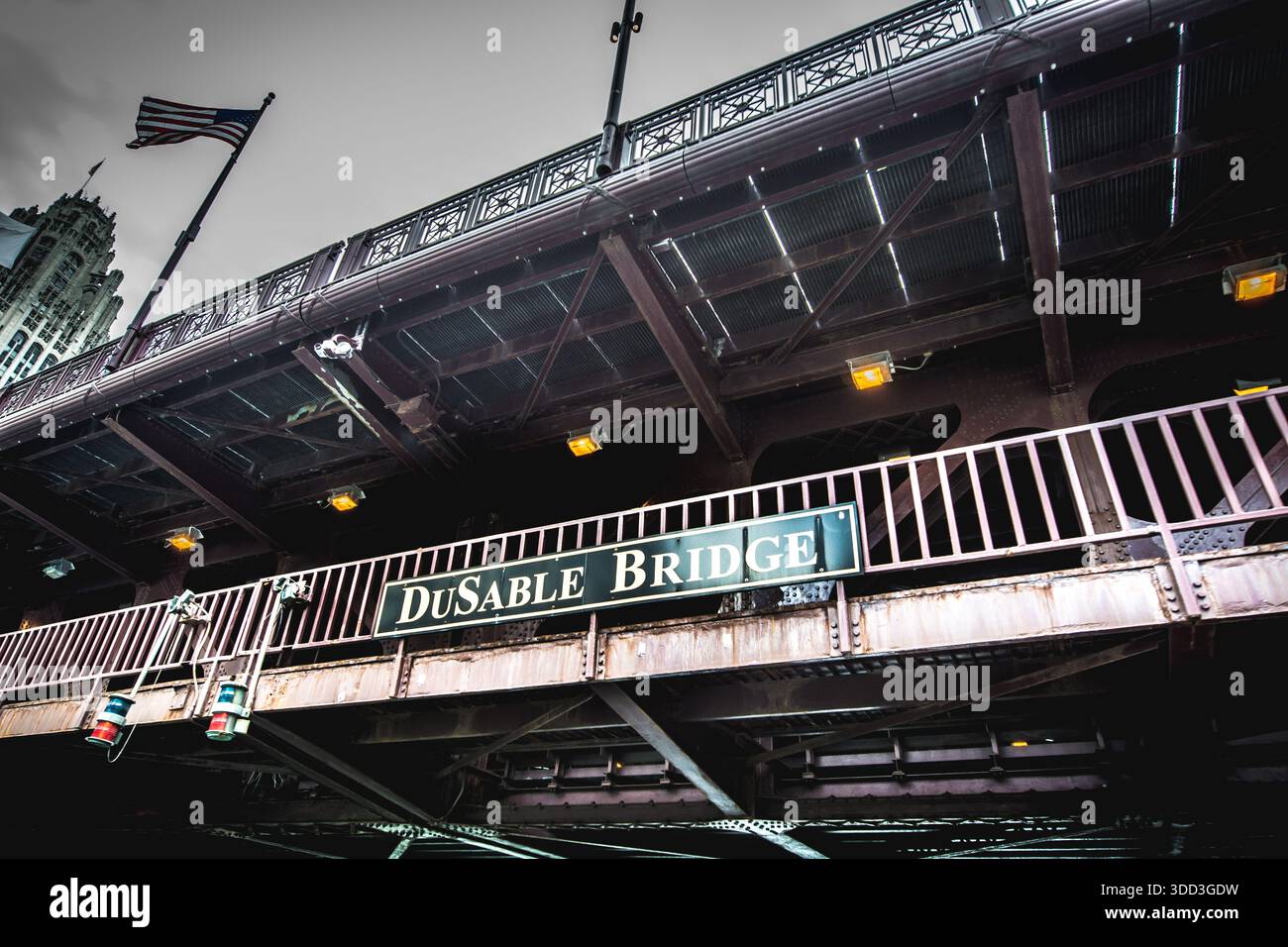 Unterseitenansicht der historischen DuSable-Brücke an der Michigan Avenue mit der Straßenschilder-Plakette und der amerikanischen Flagge in Chicago, Illinois. Stockfoto