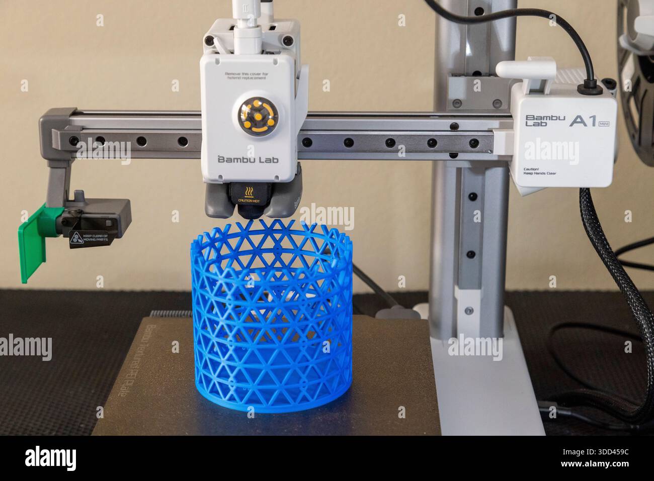 Ein 3D-Drucker, der einen zylindrischen, blauen Isogrid-Stifthalter druckt Stockfoto