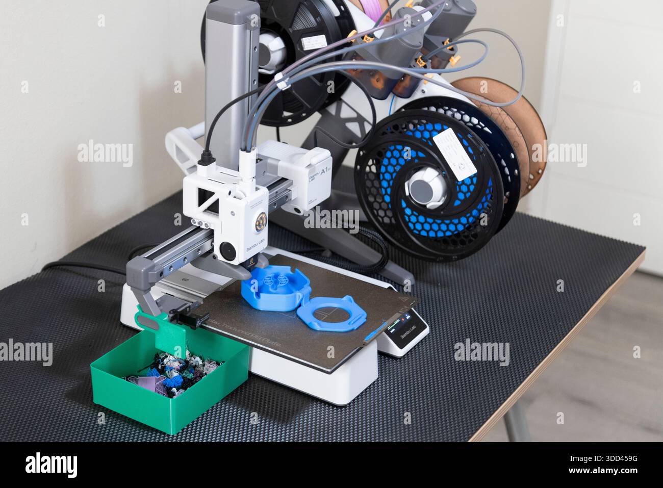 Foto eines 3D-Druckers, der eine blaue Kabelspule aus Kunststoff druckt Stockfoto