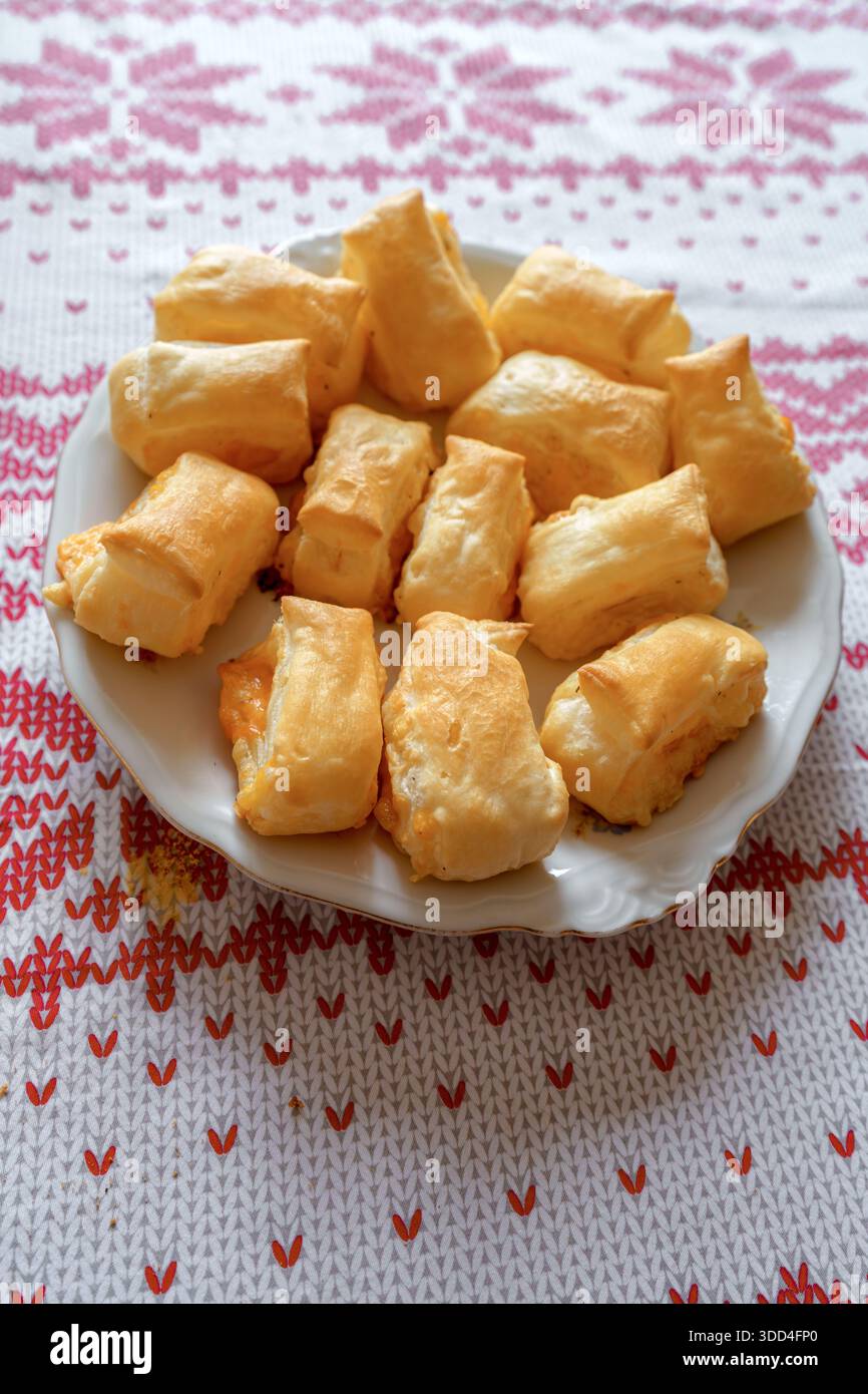 Nahaufnahme von frisch gebackenem herzhaftem Käsegebäck mit einer knusprigen goldenen Kruste. Hausgemachte Vorspeise auf einem Holzbrett mit selektivem Fokus. Stockfoto