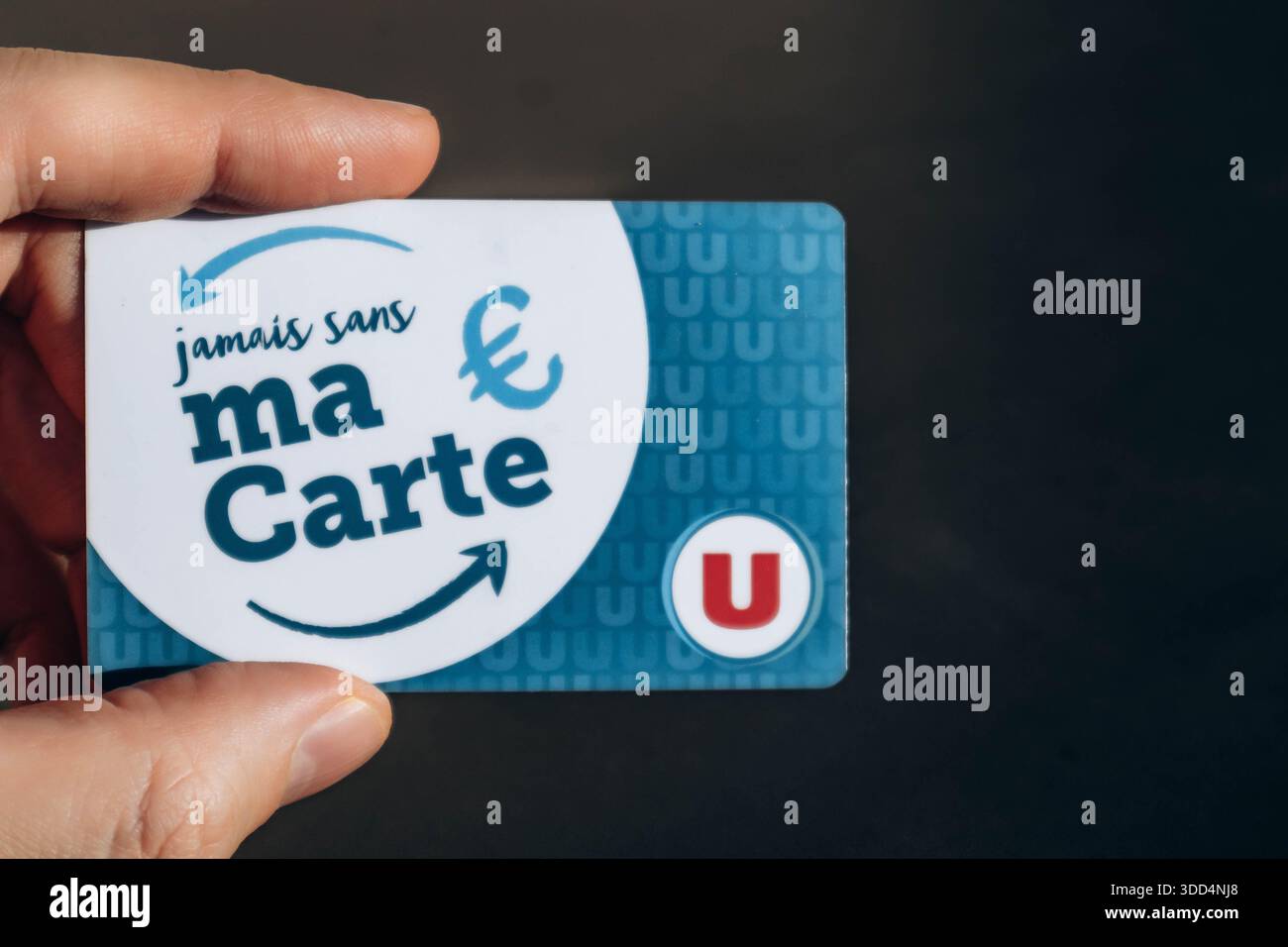 Nizza, Frankreich - 9. Dezember 2025: Hand mit U-Supermarkt-Treuekarte vor neutralem Hintergrund Stockfoto