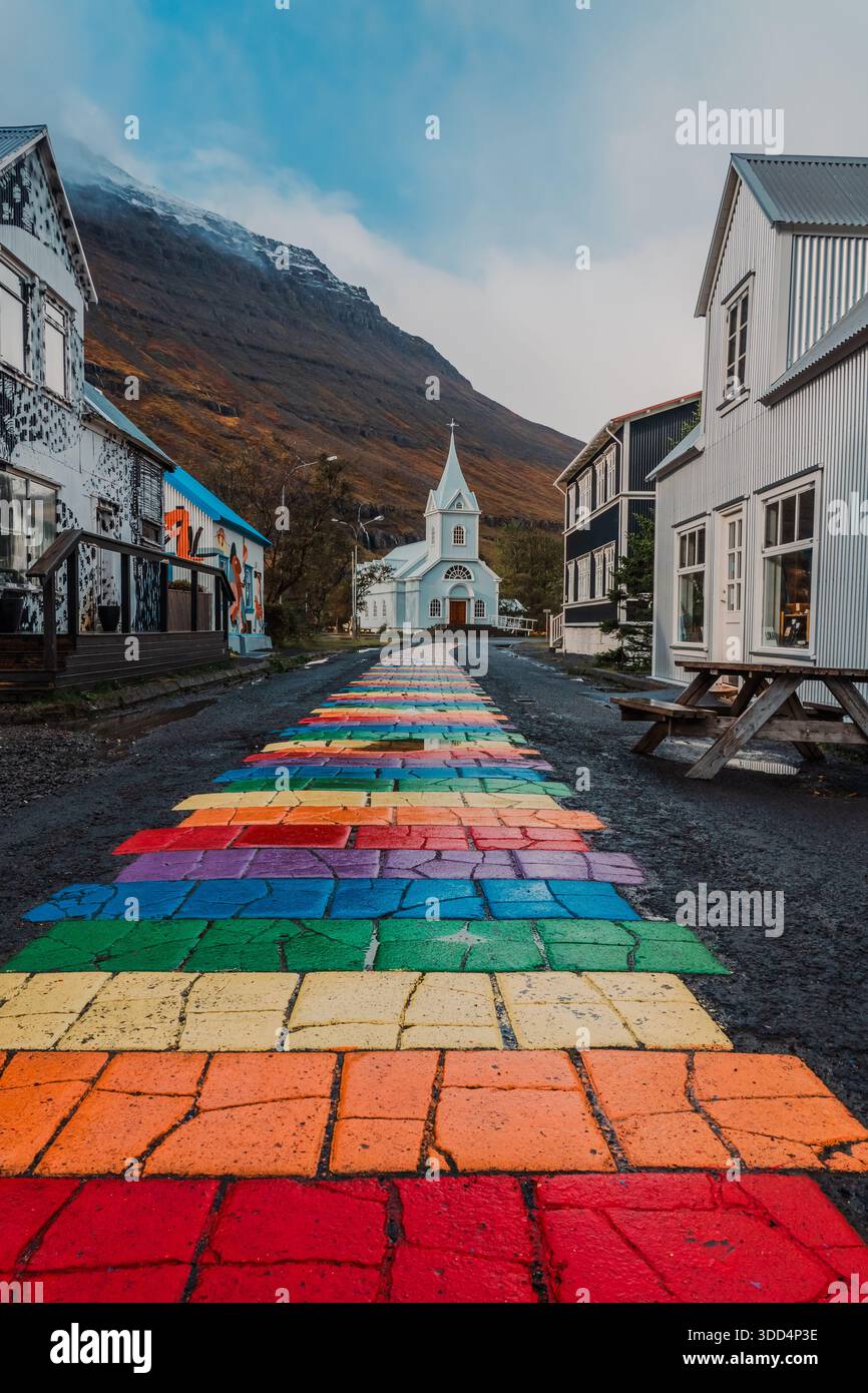 Rainbowstreet, eine der beliebtesten Grafiken in Ost-Island. Blue Church, Geschäfte und Restaurants. Bunte Straße, lgbtq, Frieden, Regenbogen. Stockfoto