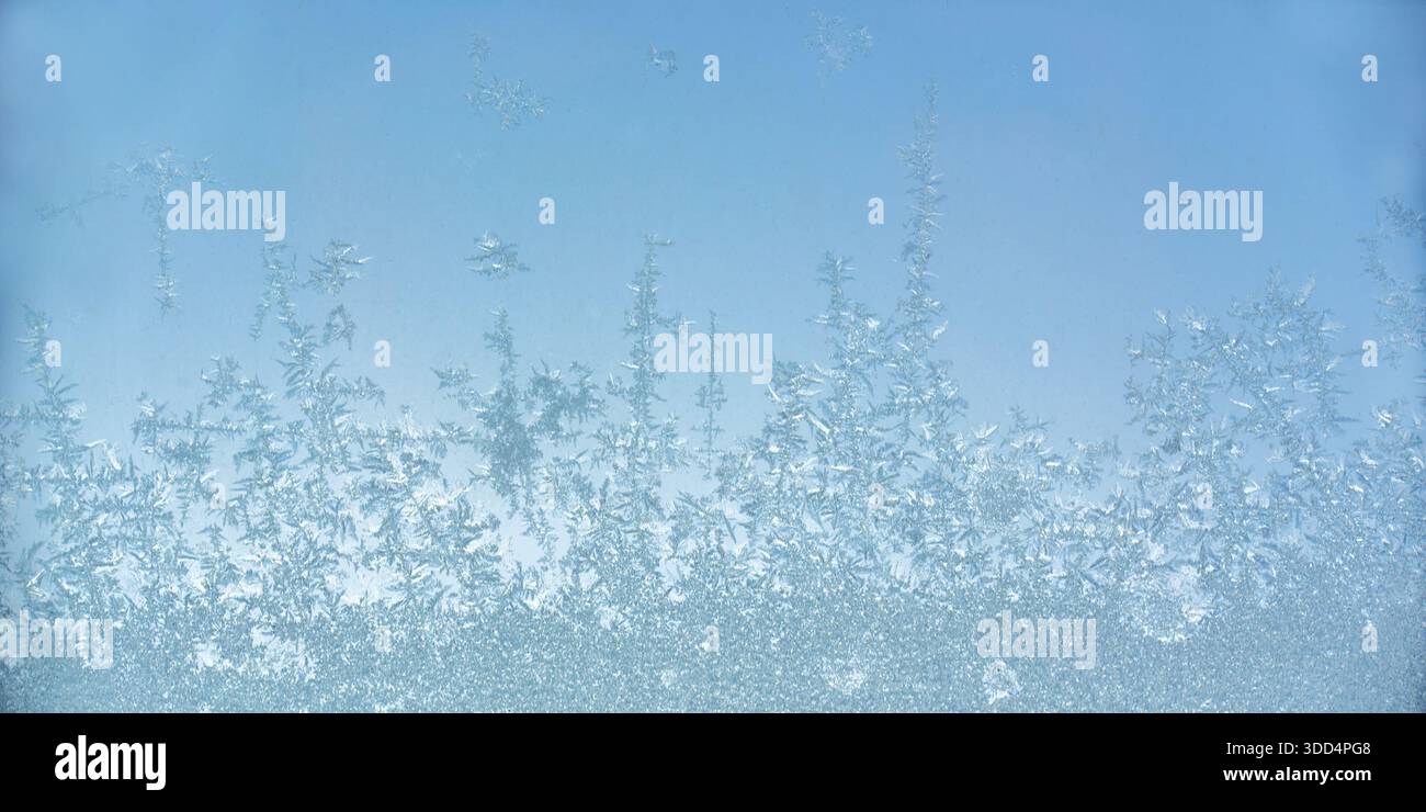 Nahaufnahme von Eiskristallen auf einer frostigen Fensterscheibe Oberfläche, eiskaltes Muster, abstrakter Hintergrund des kalten Winters Stockfoto