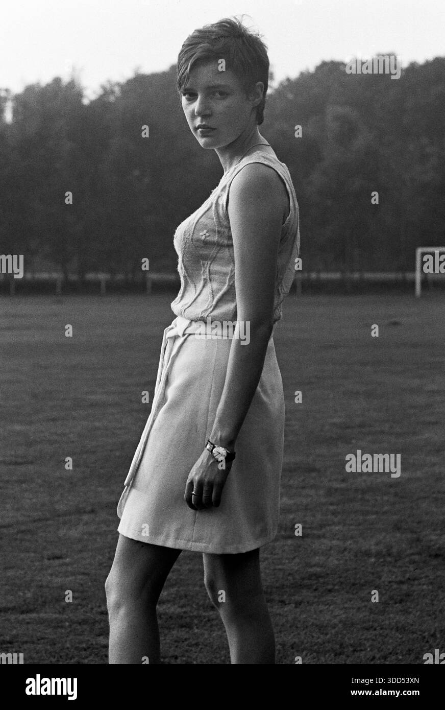 60er Jahre, 02.08.1969, Menschen, Frauen, Mädchen 17 bis 20 Jahre, Foto-Shooting mit Humor bringt Freude und Spaß auf einem Fußballplatz in Holland, mittlere Nahaufnahme, ärmelloser Pulli und Wickelrock, Minirock, kurze Haare, Monika ist enttäuscht und ungeduldig und skeptisch, sie blickt auf den Fotografen, Niederlande Stockfoto