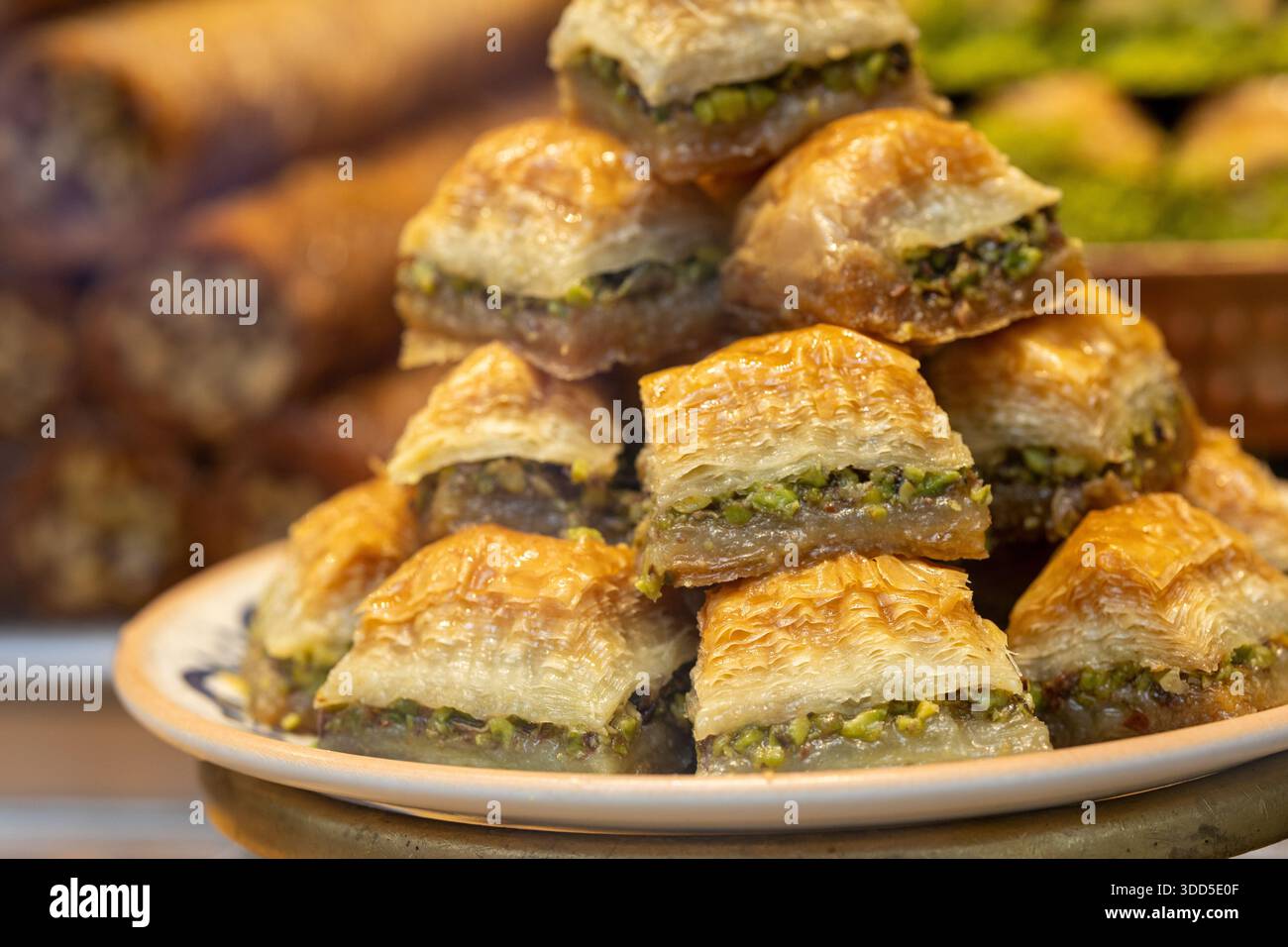 Aus nächster Nähe sehen Sie ein traditionelles türkisches Dessert, bekannt als fıstık Sarma, eine reiche und süße Pistazienrolle, die in Sirup getränkt ist. Diese Delikatesse im Baklava-Stil fea Stockfoto