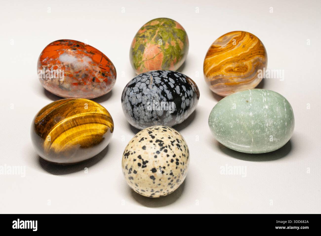 Sammlung von polierten Halbedelsteinen in eiförmiger Eierform - roter jaspis, Jade, Tigerauge, Schneeflocken-Obsidian, unakit, dalmatierungsstein, Achat Stockfoto