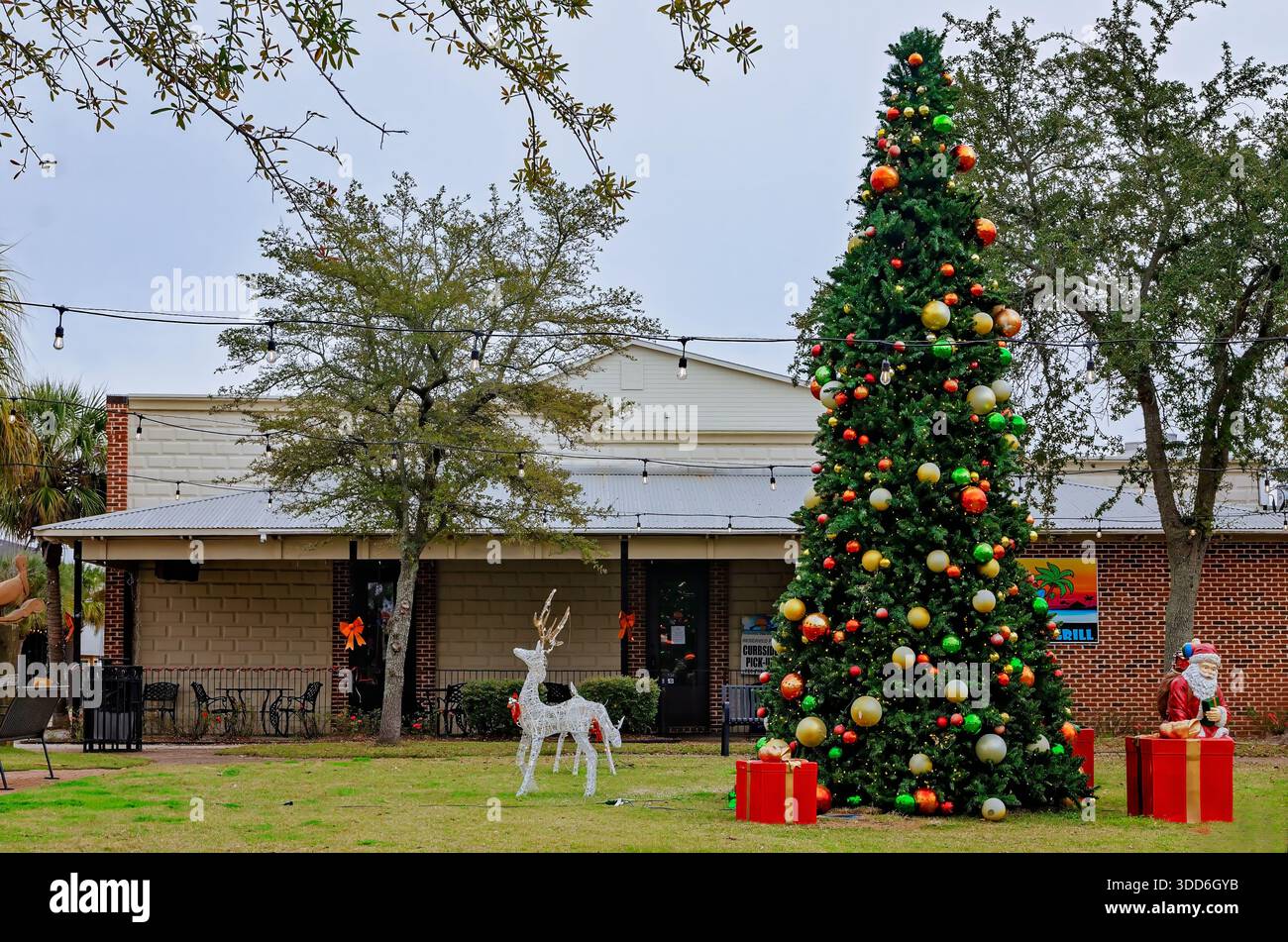 Ein Weihnachtsbaum wird zusammen mit anderen Weihnachtsschmuck im Grünraum von Downtown Pascagoula ausgestellt, umgangssprachlich „The Green“ genannt. Stockfoto