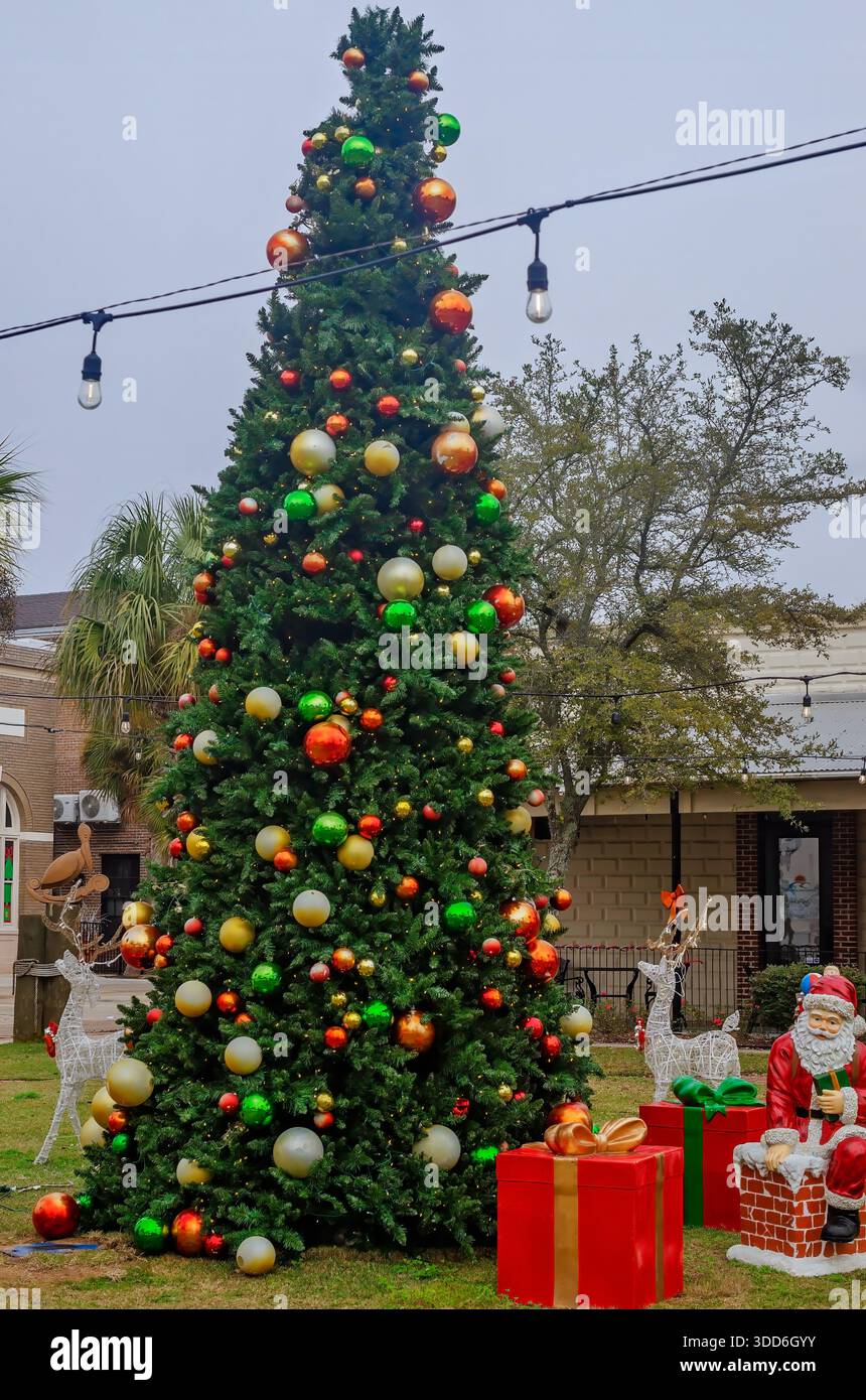 Ein Weihnachtsbaum wird zusammen mit anderen Weihnachtsschmuck im Grünraum von Downtown Pascagoula ausgestellt, umgangssprachlich „The Green“ genannt. Stockfoto