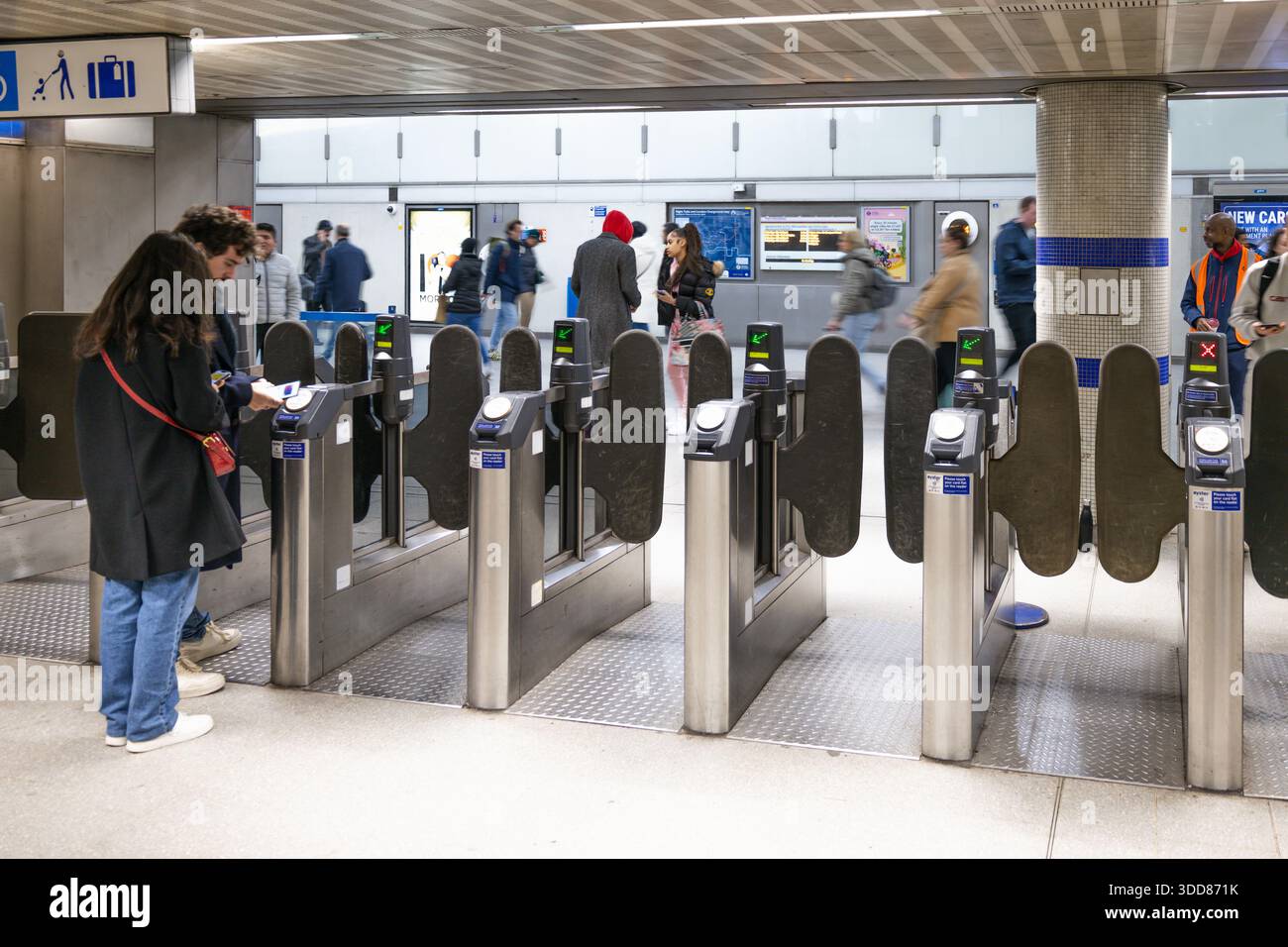 Geschäftiger Eingang der U-Bahn-Station mit Pendlern, die automatisierte Barrieren passieren. London, Großbritannien, 25. Februar 2024 Stockfoto