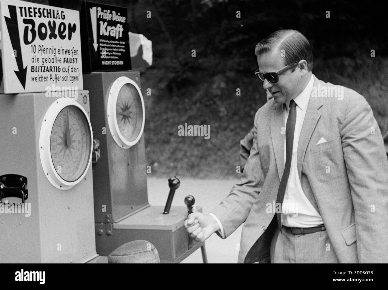 Sechzigerjahre, 26.08.1967, Deutschland, Menschen, Maenner, Freizeit, Gesundheit, Wellness, Fitness, Anstrengung, Heinz 30-35 Jahre im Anzug mit Krawatte testet seine Kraft an einem Spielgeraet zum Kraeftemessen, Bergisches Land, Nordrhein-Westfalen, NRW Sechzigerjahre, 26.08.1967, Deutschland, Menschen, Maenner, Freizeit, Gesundheit, Wellness, Fitness, Anstrengung, Heinz 30 bis 35 Jahre kurzes Haar im Anzug mit Krawatte testet seine Kraft an einem Spielgeraet zum Kraeftemessen im Münchner Brueckenpark nahe der Münchner Talbruecke ueber die Wupper zwischen Remscheid und Solingen, Bergisc Stockfoto