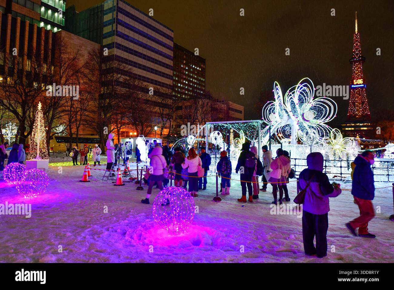 Sapporo, Hokkaido, Japan - 17. Dezember 2025: Schneeskulptur in hellen Farben, mit dem Sapporo Fernsehturm als Kulisse im Odori Park wint Stockfoto