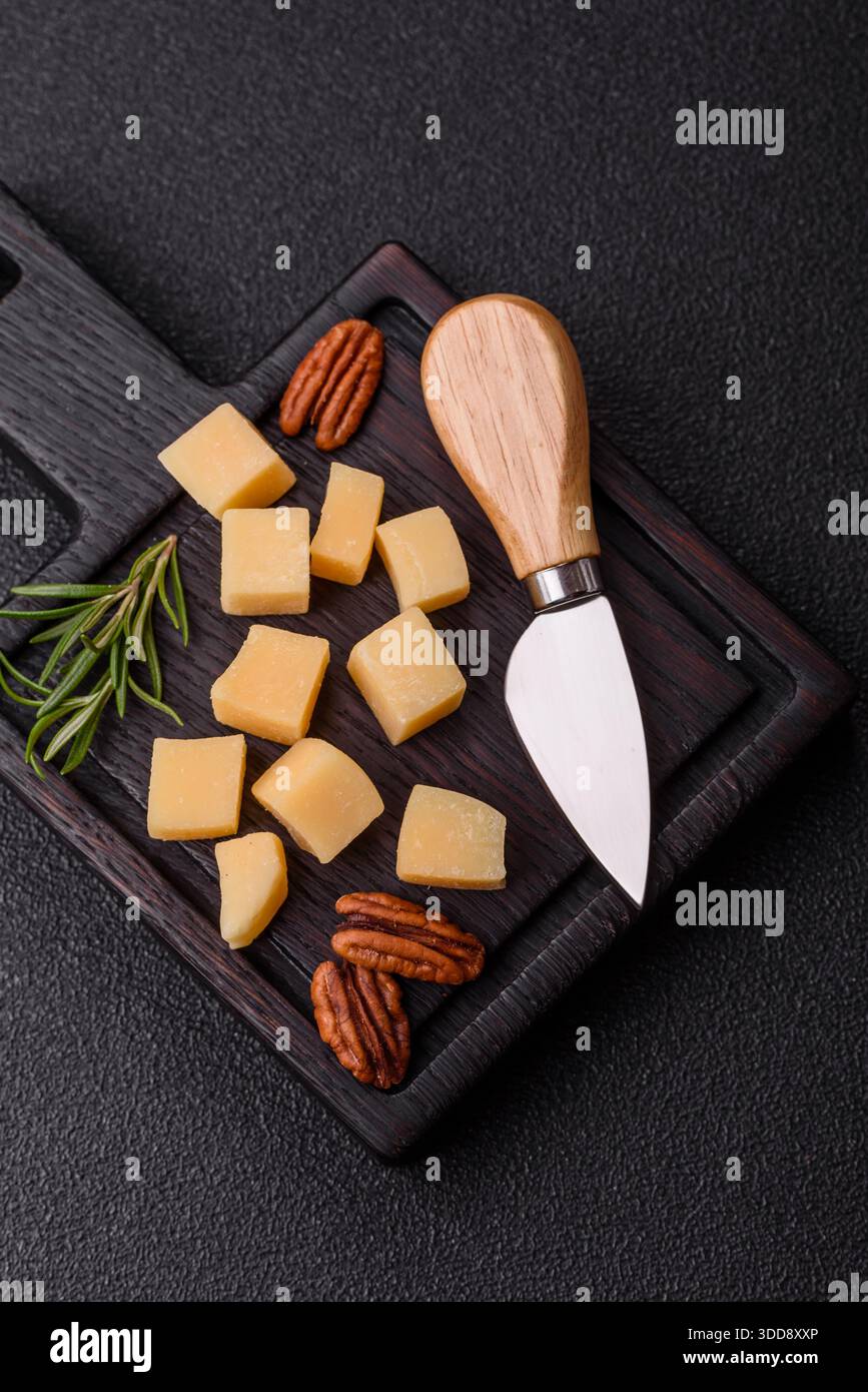 Gewürfelter Cheddar, Gouda oder Parmesankäse auf einem Schneidebrett. Gewürfelter Käse als Lebensmittelhintergrund für Ihr Design Stockfoto