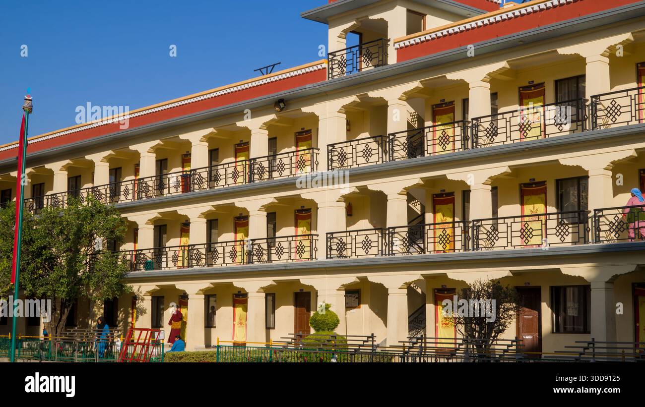 Modernes gelbes Gebäude mit symmetrischem Design, mehreren Ebenen und Balkonen, das einen klaren und strukturierten architektonischen Stil bietet. Stockfoto