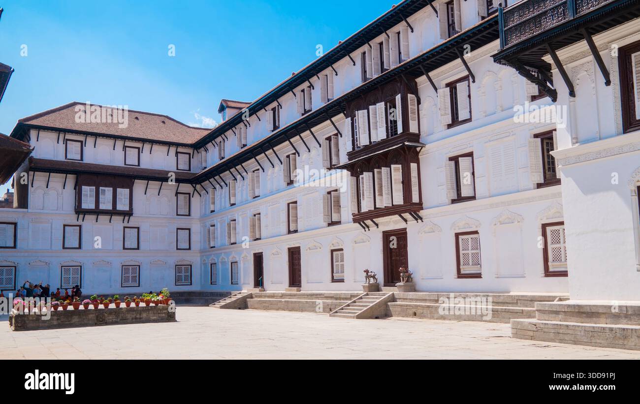 Historisches mehrstöckiges Gebäude mit zahlreichen Fenstern unter einem klaren blauen Himmel im Hanuman Dhoka Palace. Stockfoto