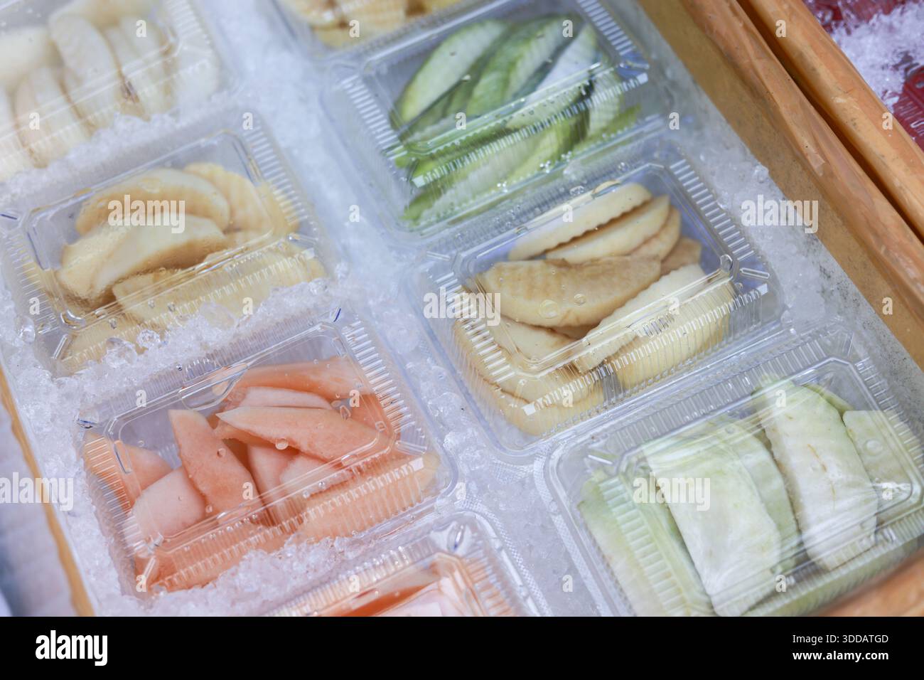 Frisch geschnittene tropische Früchte in Plastikbehälter zum Verkauf auf dem asiatischen Markt mit appetitlichen und gesunden Snack-Optionen bereit zu essen mit lebendigem c Stockfoto