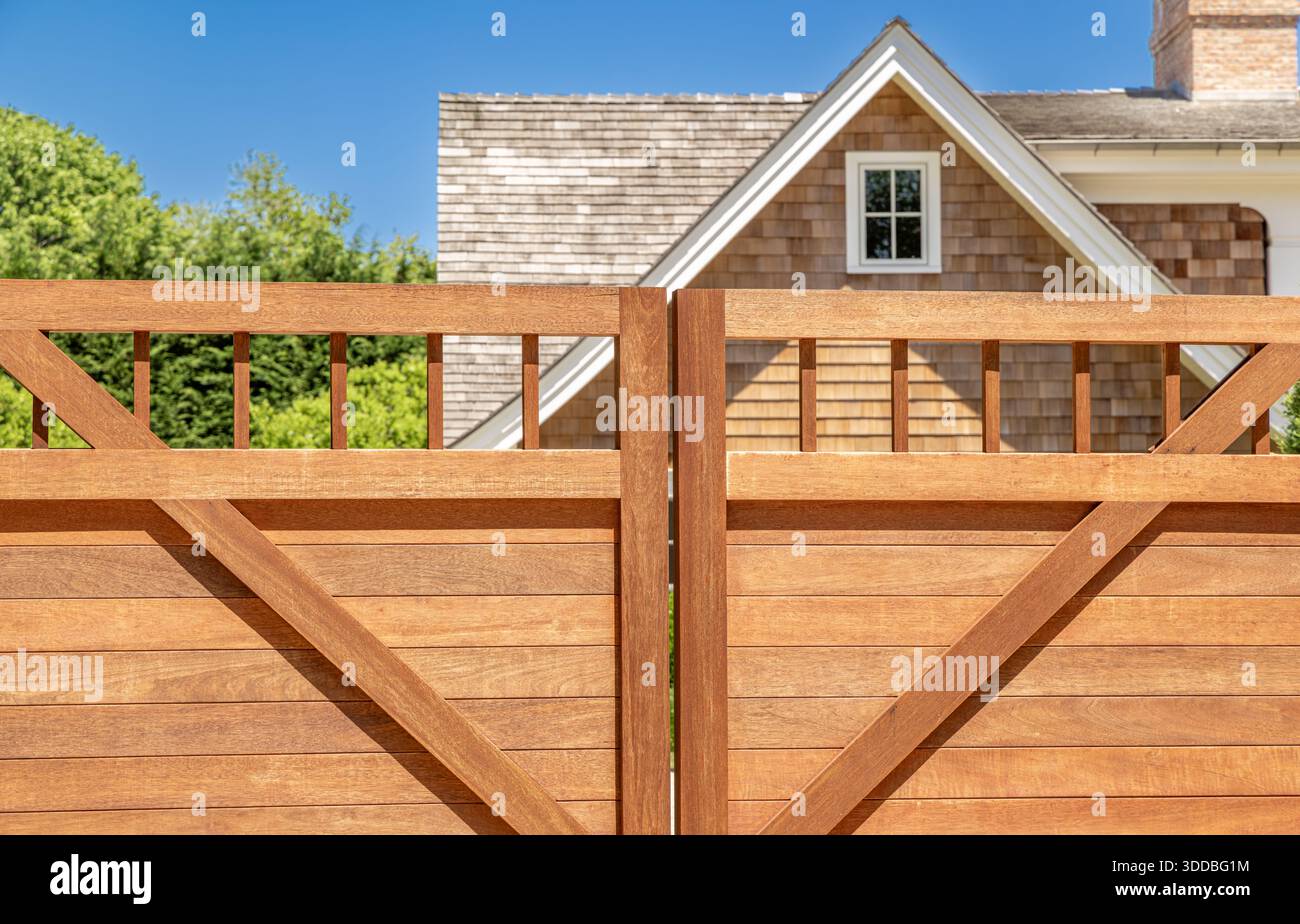 Nahaufnahme eines brandneuen Mahagoni-Tors mit einem Teil eines Hauses direkt dahinter Stockfoto