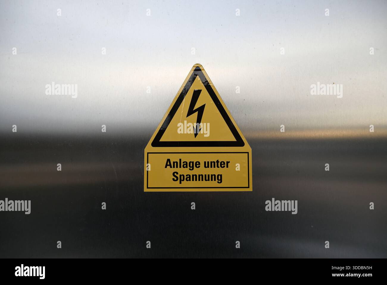 Warnschild „Wärmepumpe“. Reflektierende Wärmepumpe mit Warnschild für hohe Spannung. Im Freien. Silberfarben. Gelbe Farbe. Stockfoto