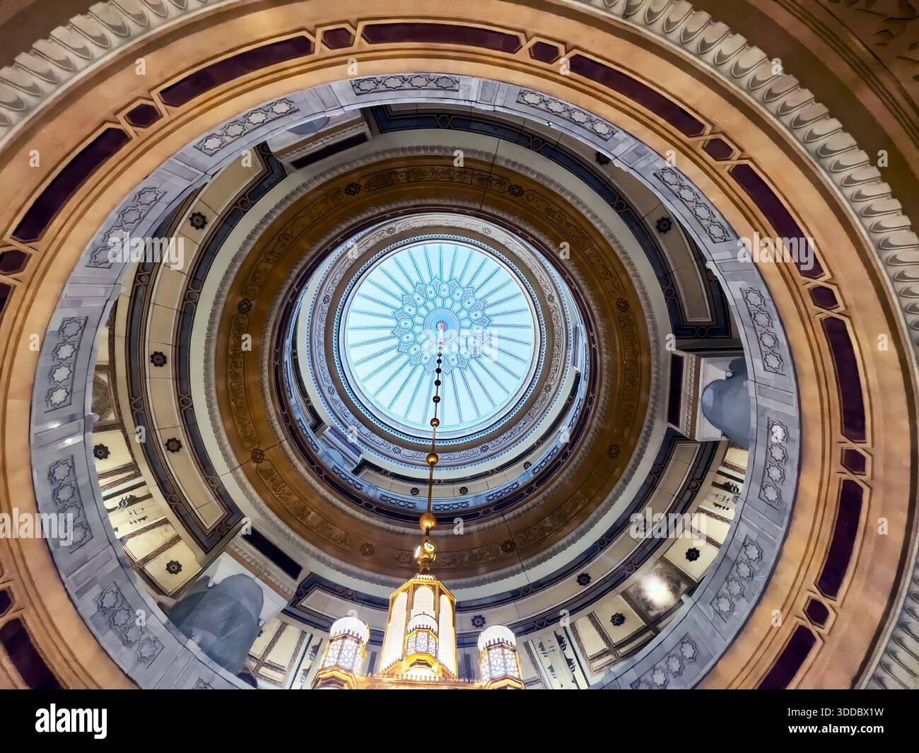 Mekka, Saudi-Arabien – 18. Dezember 2025: Goldener Kronleuchter hängt im Masjid al-Haram und hebt die islamische Innenbeleuchtung hervor. Stockfoto
