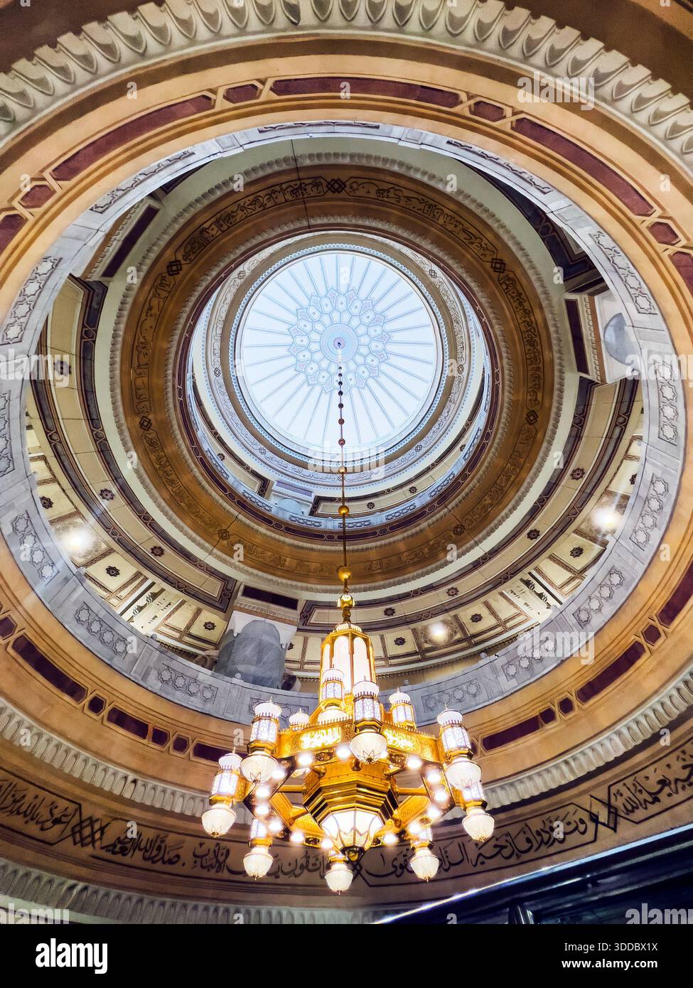 Mekka, Saudi-Arabien – 18. Dezember 2025: Goldener Kronleuchter hängt im Masjid al-Haram und hebt die islamische Innenbeleuchtung hervor. Stockfoto
