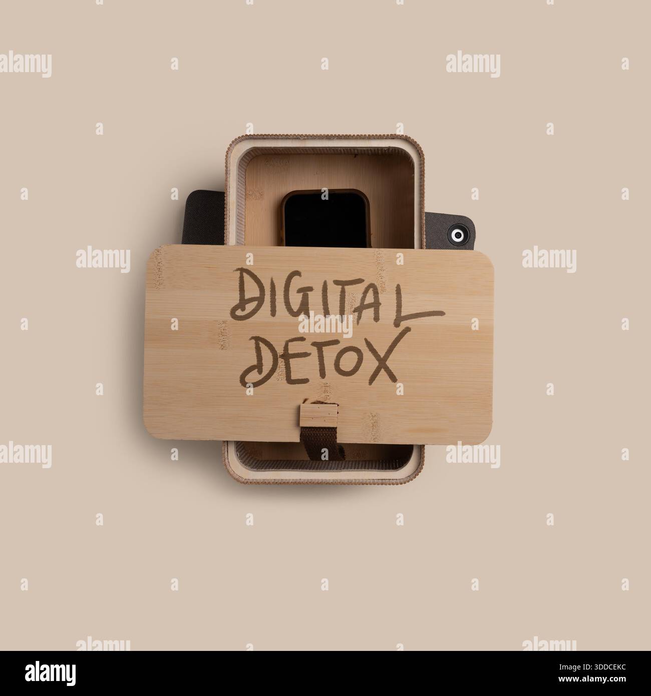 Draufsicht einer Holzbox mit der Aufschrift Digital Detox mit einem Smartphone im Inneren. Konzept der digitalen Detox, Bildschirmsucht, Achtsamkeit, psychische Gesundheit, balan Stockfoto