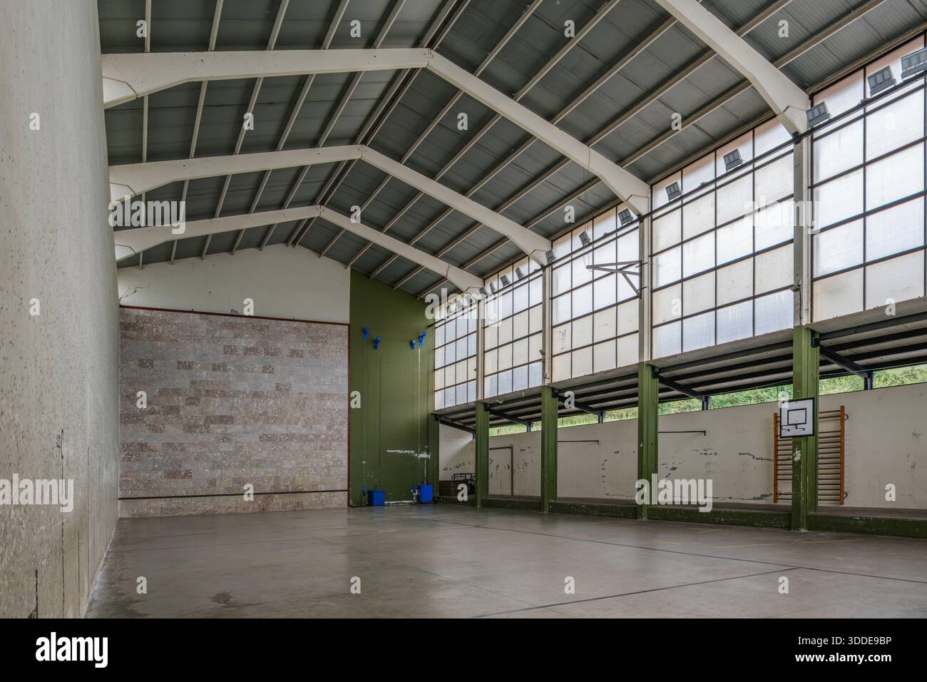 Kleines gemeinschaftliches Indoor Sports Center mit Steinmauer und Basketballkorb Stockfoto