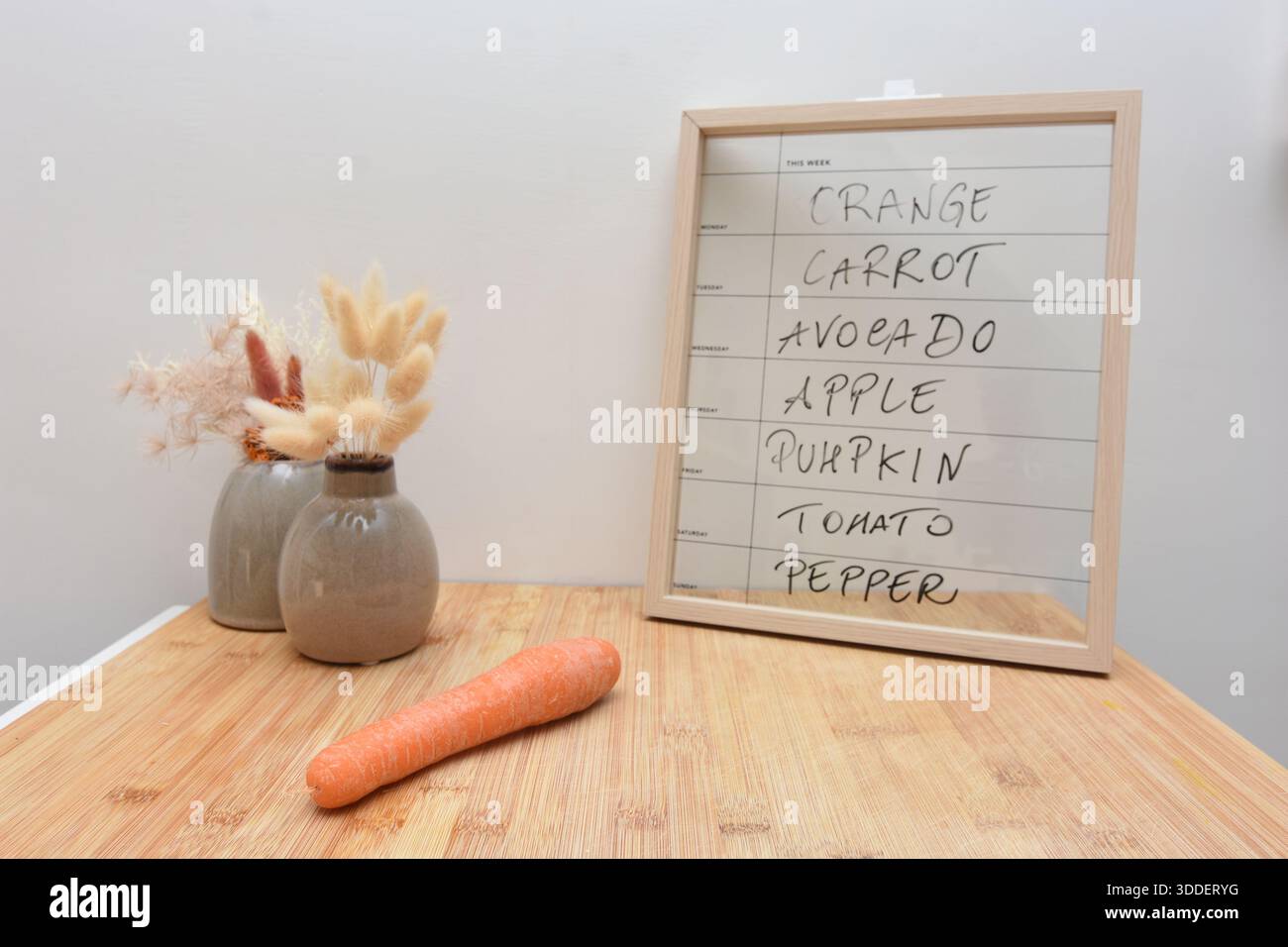 Ein Brett und eine Karotte zeigen an, welches Essen am Dienstag zu essen ist Stockfoto