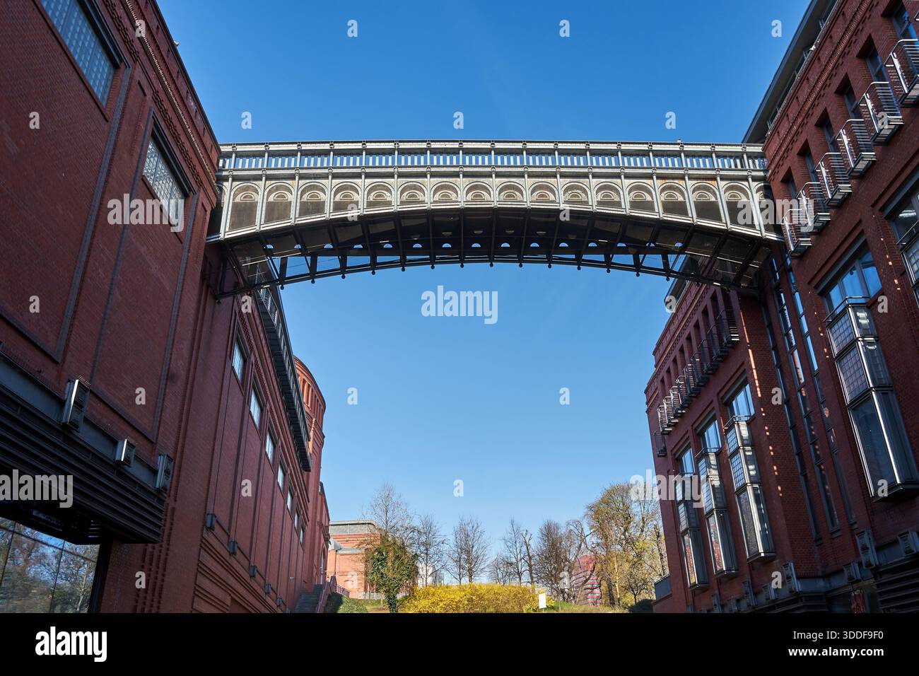 Fußgängerbrücke aus Metall zwischen den Gebäuden der restaurierten alten Brauerei in Posen, Polen Stockfoto