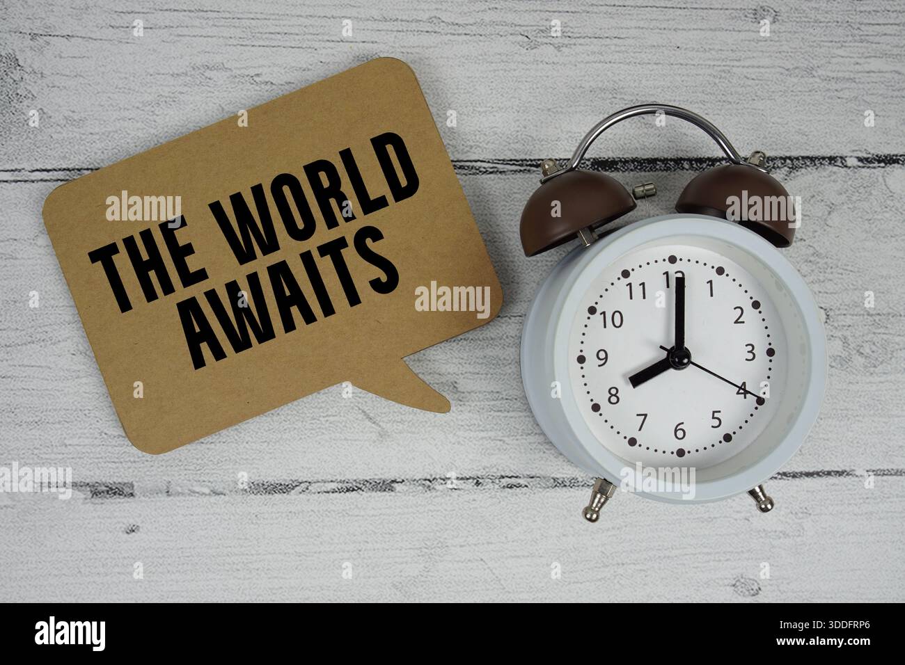 Die Welt wartet auf Text mit Wecker auf hölzernem Hintergrund Stockfoto