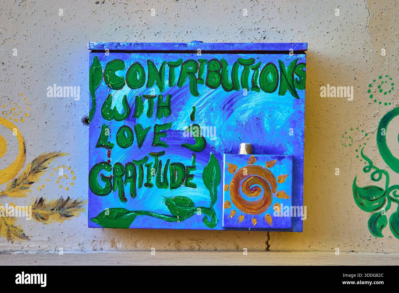 Handgemalte Spendenbox mit Sonnenmotiv und Danksagung an der Wand Stockfoto