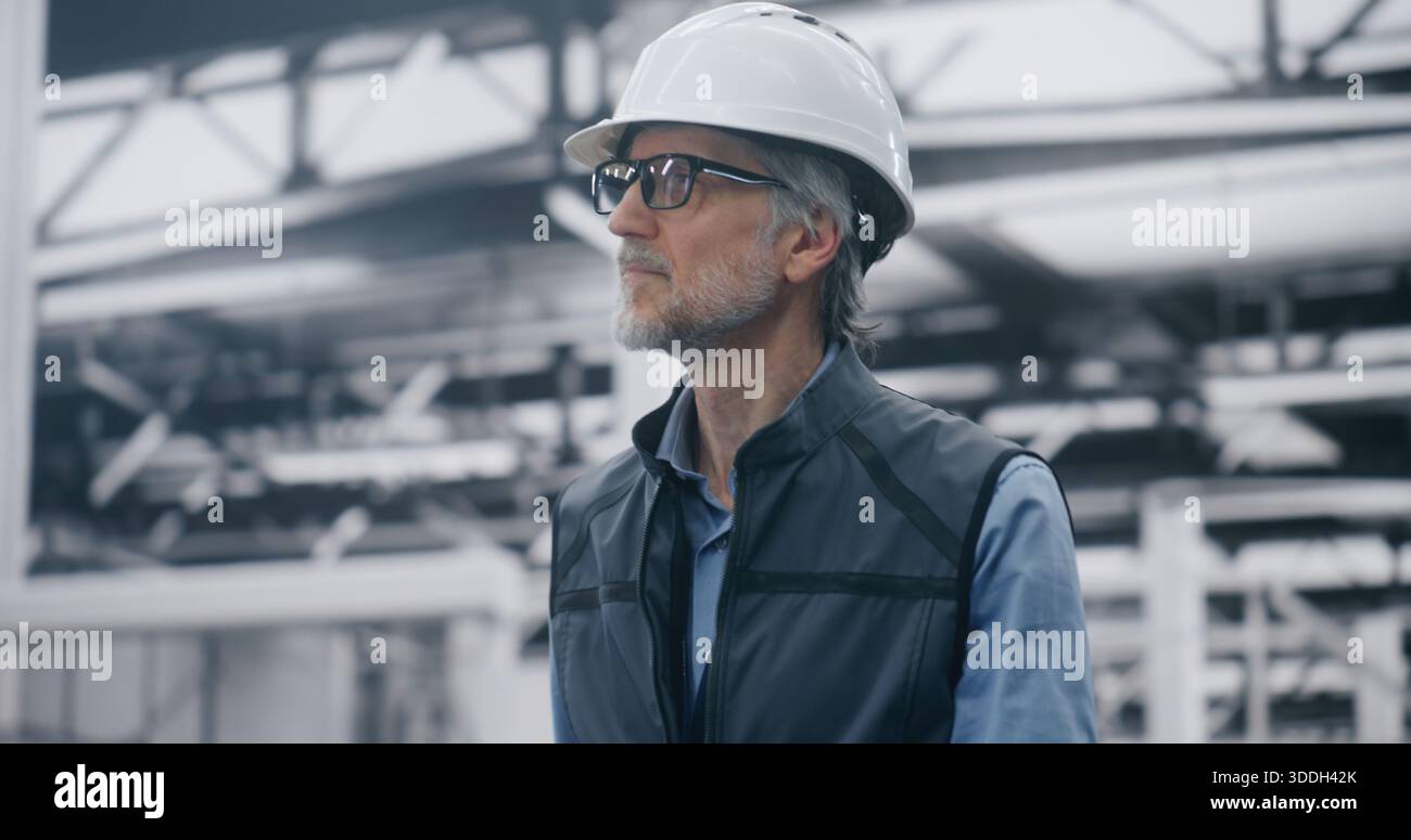 Spezialist für die Beurteilung der Effizienz der Produktionslinie vor Ort. Männlicher technischer Spezialist für Sicherheitsausrüstung bewertet die Effizienz der Produktionslinie in der Roboteranlage. Operative Exzellenz, Leistungsbeurteilung. Stockfoto