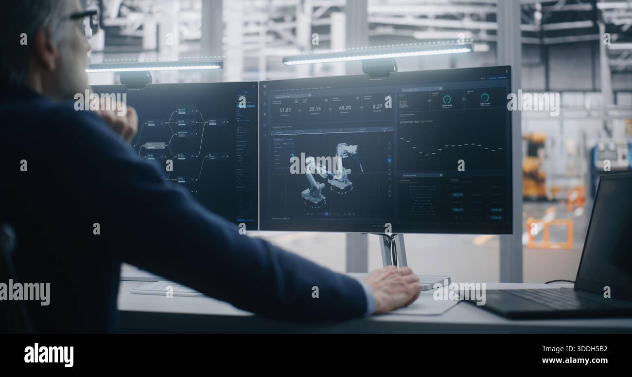 Fachkundige IT-Integration, hochqualifizierter Professional mit Grey Hair verwaltet komplexe Fabrikautomatisierungssysteme mit zwei Monitoren und einem Laptop. Konzept der IT-Integration und Expertensystem-Management. Stockfoto