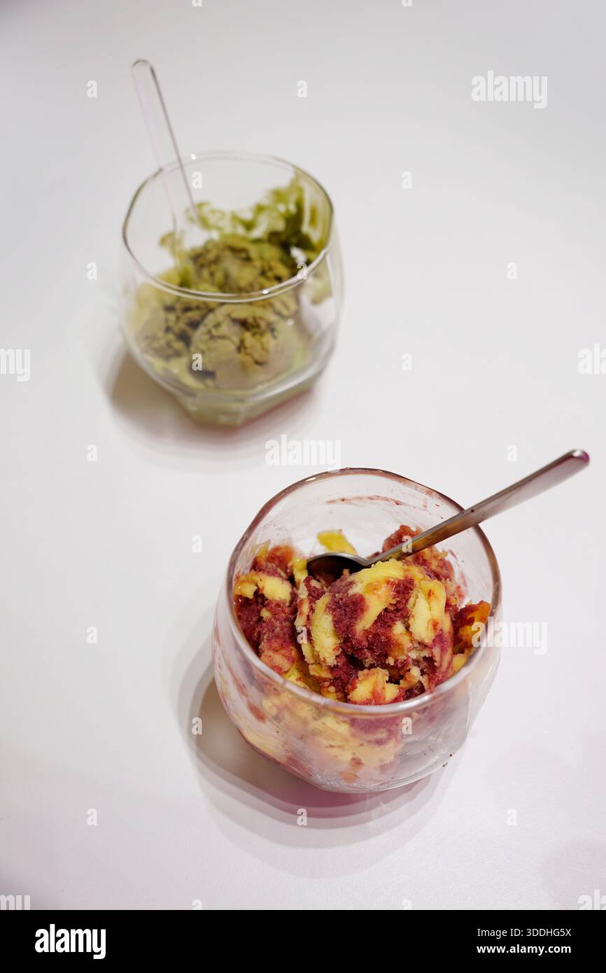 Matcha-Eis und Mango-Erdbeersorbet in Glasbechern auf weißem Hintergrund Stockfoto