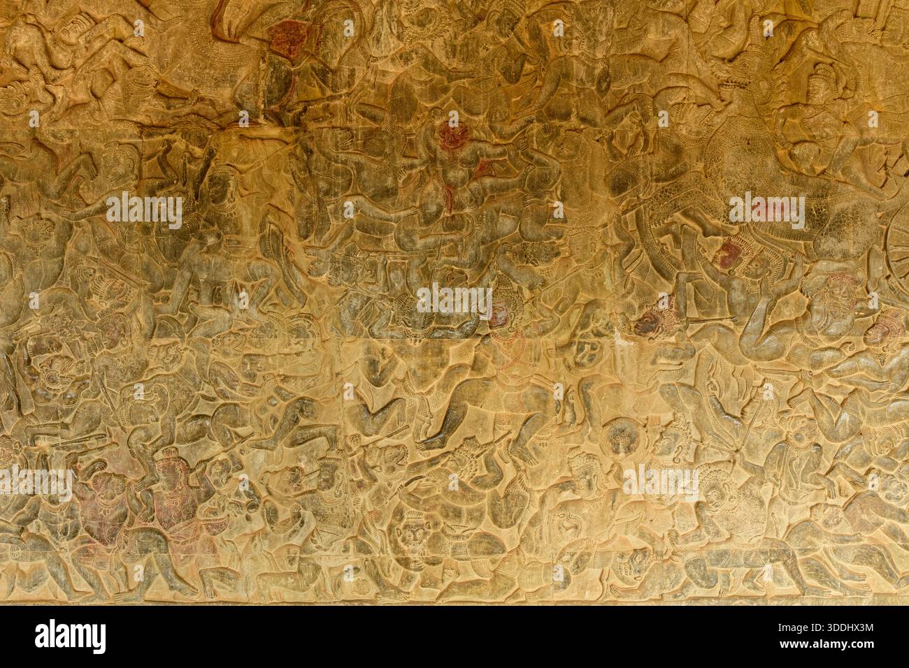 Das komplizierte Flachrelief aus Sandstein zeigt eine dynamische Schlachtszene auf der Ehrenterrasse von Angkor VAT. Die verwitterten Schnitzereien zeigen mehrschichtige Figuren, kunstvolle Kopfbedeckungen und strukturierte Oberflächen, die die Kunst der alten Khmer-Handwerkskunst zeigen. Stockfoto