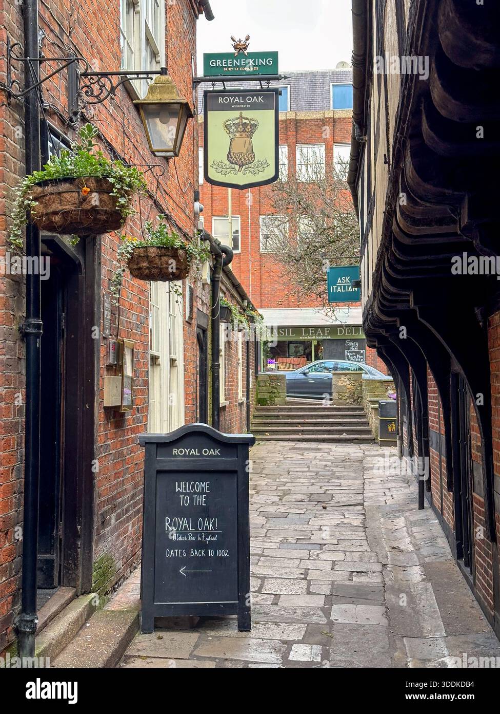 Eine enge historische Gasse führt zum Royal Oak Pub in Winchester, Hampshire, England, Großbritannien - Smartphone-aufgenommenes Stockfoto