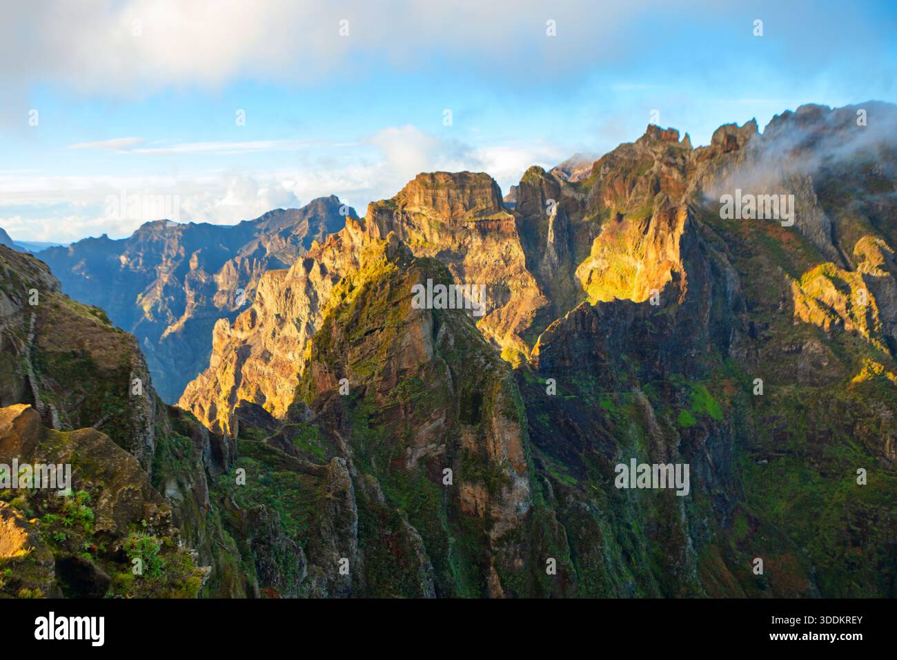 Atemberaubende Berglandschaft Pico do Arieiro in Madeira, Portugal, schroffe Gipfel und Wanderweg über Wolken. Morgensonne dramatisch Stockfoto