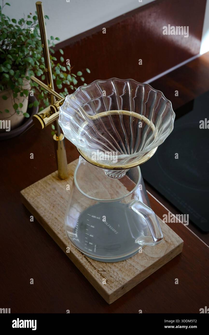 Kaffeetropfen aus klarem Glas auf Holzständer Stockfoto