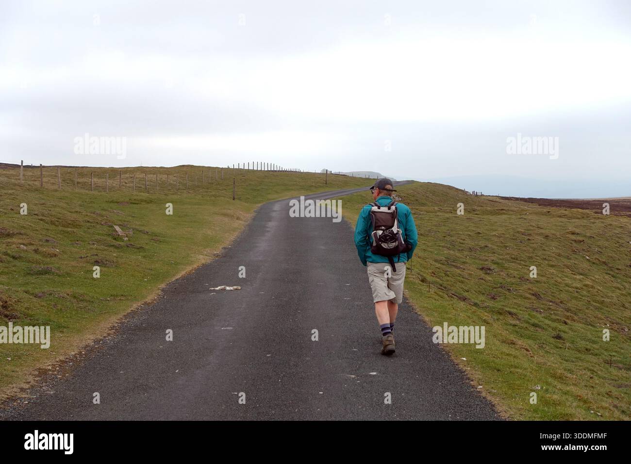 Lone Single man (Wanderer) zu Fuß auf der „Cross Top“ Road von Swaledale nach Askrigg in Wensleydale, Yorkshire Dales National Park, England, Großbritannien. Stockfoto