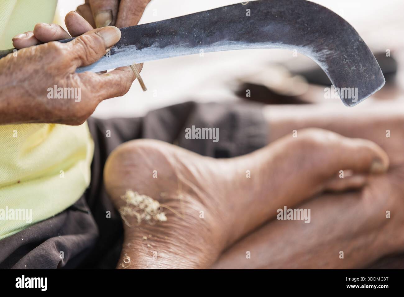 Detail eines thailändischen Handwerkers, der Bambus mit traditioneller Klinge trimmt Stockfoto