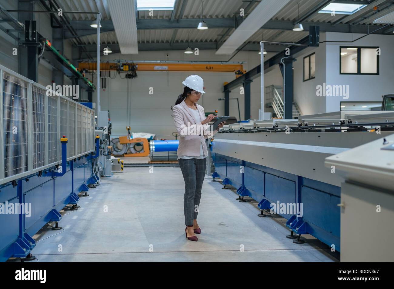 Indianerin, Betriebsleiterin, die den Produktionsprozess und die Industriemaschinen überwacht. Industrie-, Personal- und Automatisierungskonzepte. Stockfoto