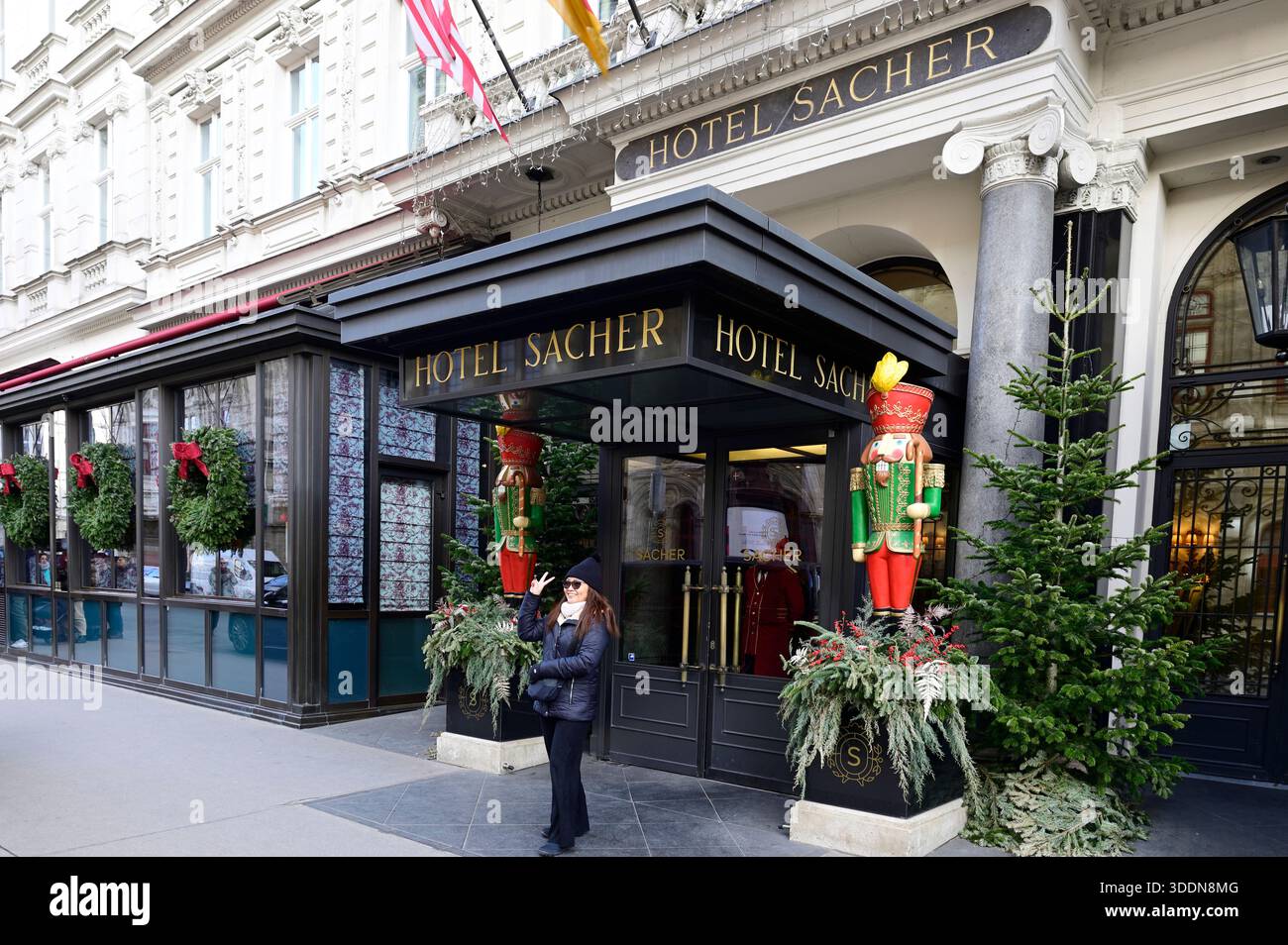 Wien, Österreich. Frau posiert für ein Selfie vor dem festlich geschmückten Hotel Sacher Stockfoto