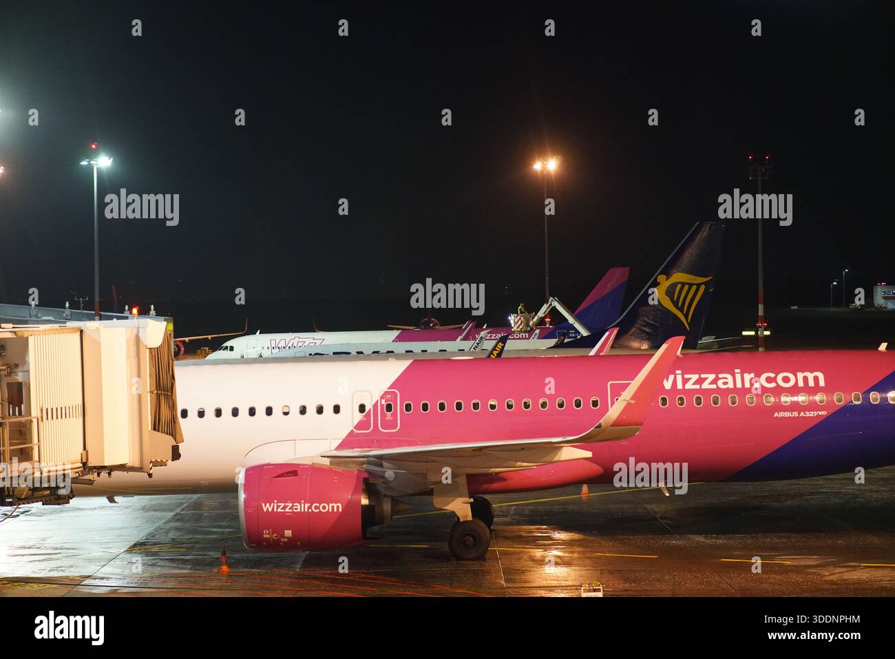 Wizz Air Flugzeuge am Abflugsteig in der Nacht im Flughafen Budapest, mit anderen Billigfluggesellschaften im Hintergrund.Budapest, Ungarn Stockfoto