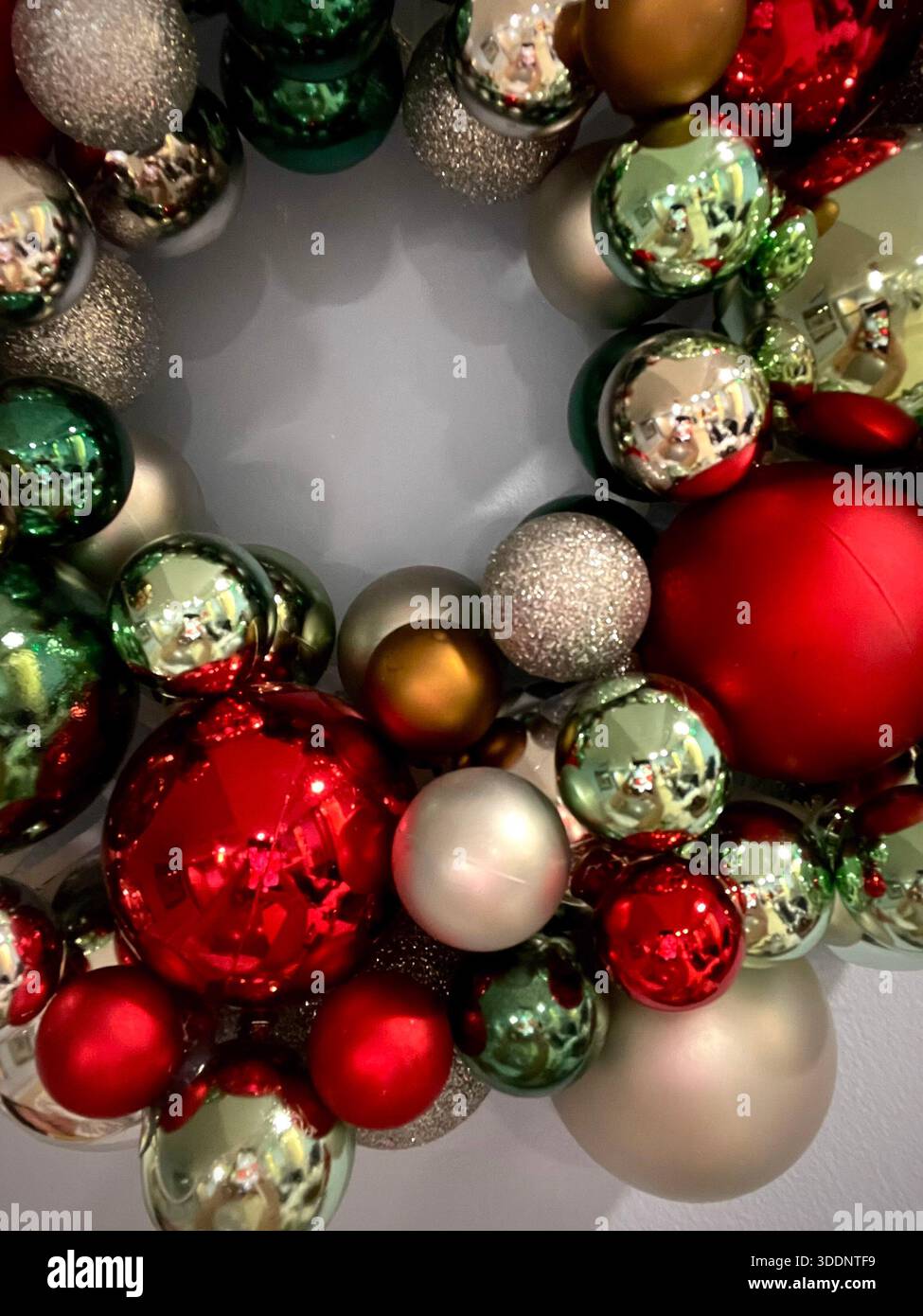 Weihnachtskranz mit glänzenden Ornamenten in rotgrüner Goldfarbe - Smartphone-aufgenommenes Stockfoto