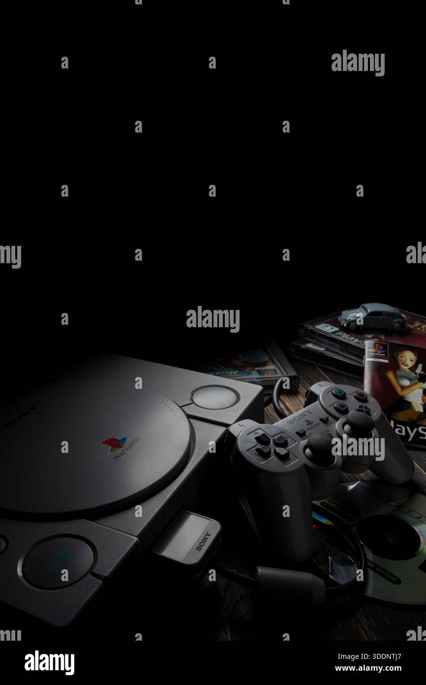 1. Januar 2026, Odessa, Ukraine. Retro-PlayStation 1-Konsole von Sony mit Controller und Spielen auf dunklem Hintergrund. Stockfoto