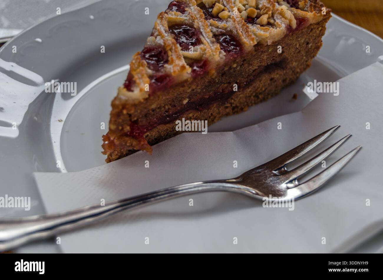 Eine Scheibe Linzer Torte, ein traditionelles österreichisches Gebäck, eine Form von Shortbread mit Obstkonserven und in Scheiben geschnittenem ​​nuts mit Lattic Stockfoto