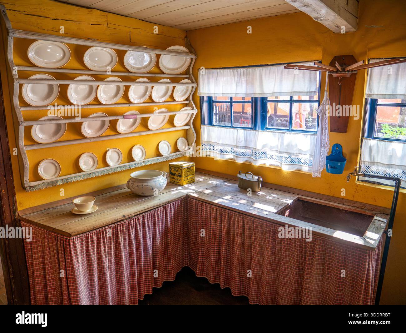 Innenraum der historischen Küche mit Holztheke und Tellern an der Wand im Farvergaarden Museum in der Altstadt von Ebeltoft, Jütland, Dänemark Stockfoto