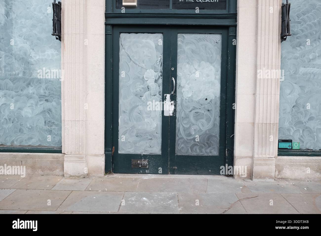 Geschlossenes Geschäft, leerer Gewerbebereich, mit weiß getünchten Fenstern, um jede Sicht nach innen zu verdecken, um Sicherheit und Privatsphäre zu gewährleisten. UK Stockfoto