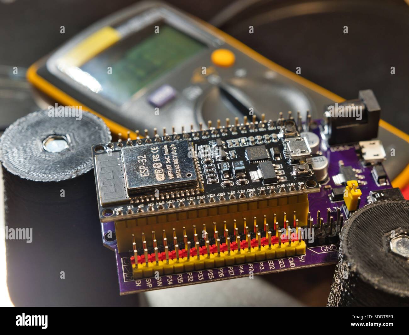 Mikrocontroller-Platine für den technischen Test; Nahaufnahme eines Ingenieurs, der die Spannung auf einer modernen Mikrocontroller-Entwicklungsplatine (PCB) mit einem digitalen m testet Stockfoto
