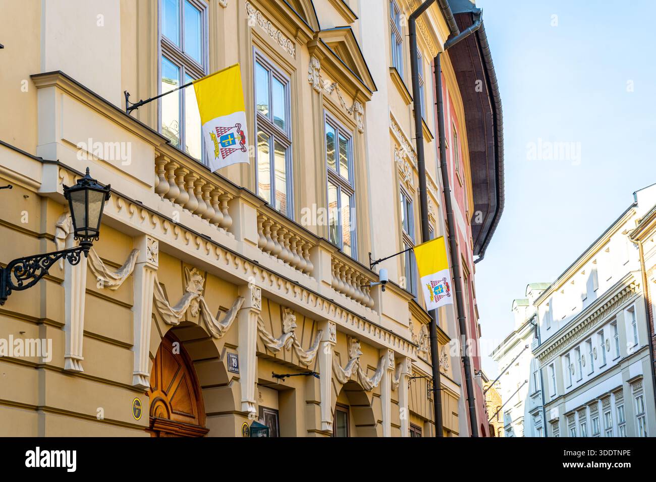 Gelbe Fahnen des Vatikans an der Wand der Gebäudefenster Stockfoto