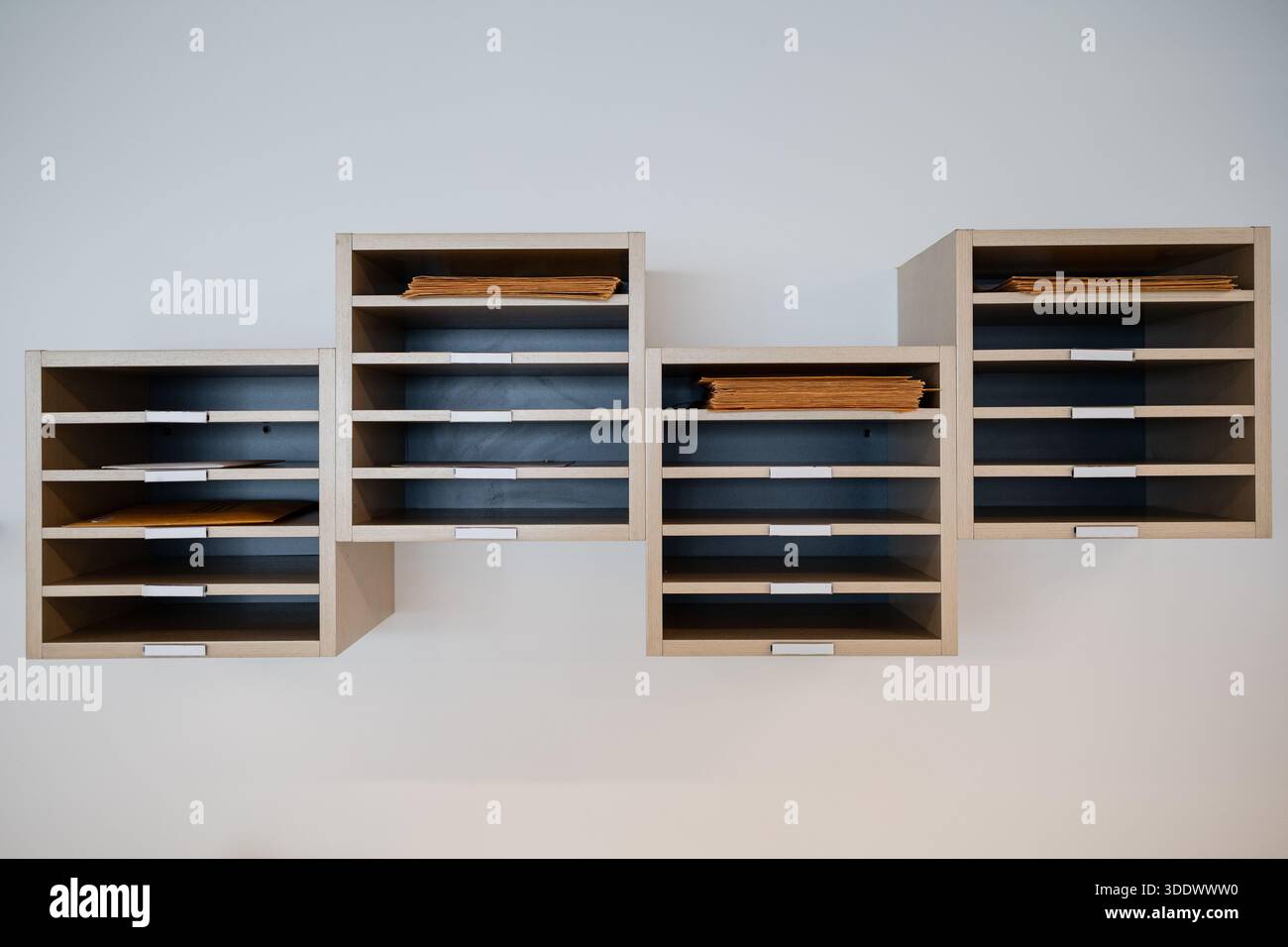 Reihen meist leerer Postfächer in einem Firmengebäude, was die Umstellung auf Fernarbeit während der COVID-19-Ära widerspiegelt. Stockfoto