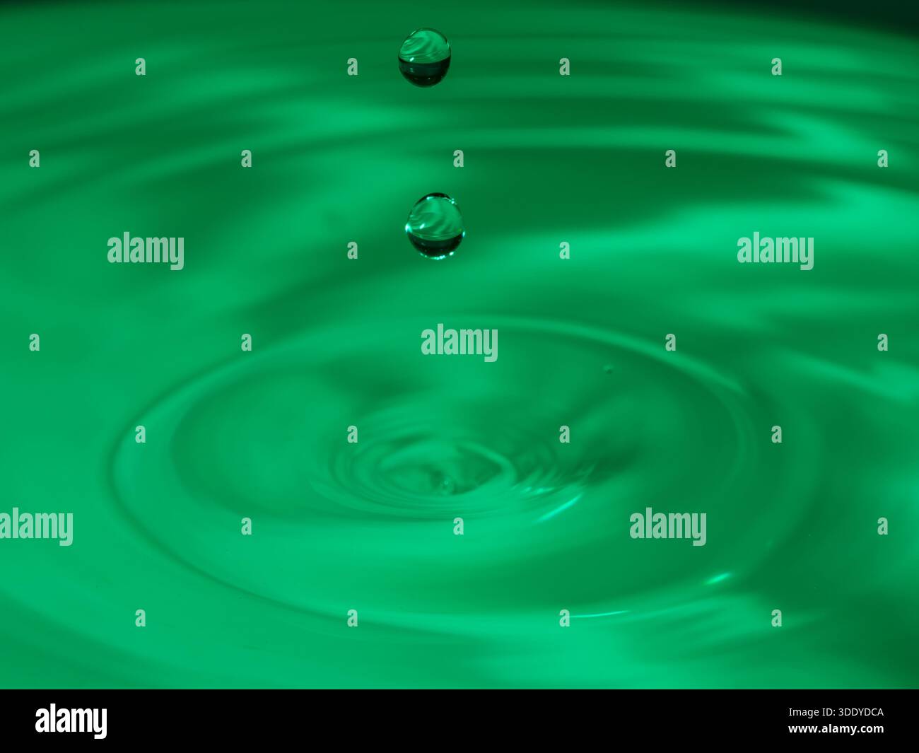Wassertropfen spritzen in einem Glas blau Stockfoto